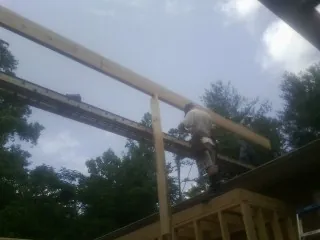 Carpenter setting a ridge beam over a new addition frame — Ice Dam Removal by Roofing Brothers in Chestnut Mound