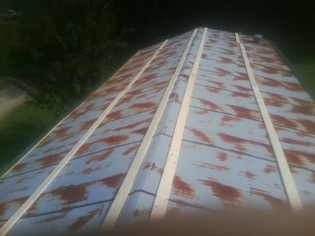 Rusted metal roof panels with new wood purlins before replacement — Storm Damage Roof Repair in Chestnut Mound by Roofing Brothers