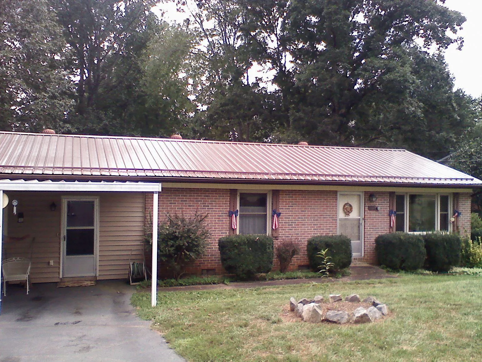 Bronze metal roof and carport on a brick ranch home — Roof Repair work by our crew in Chestnut Mound